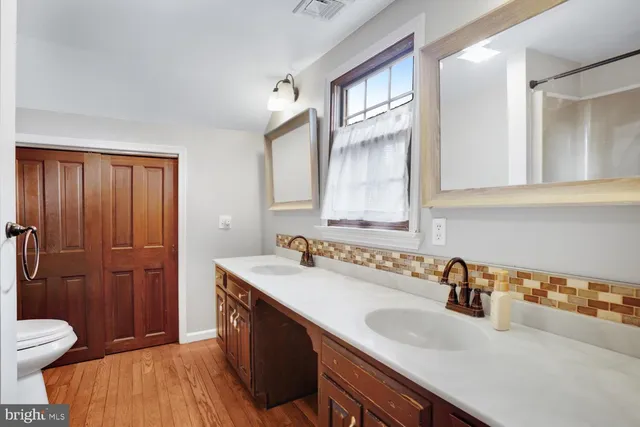 a bathroom with a sink a mirror a bathtub and shower