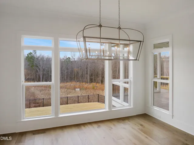 a view of a big house with a big yard and large trees