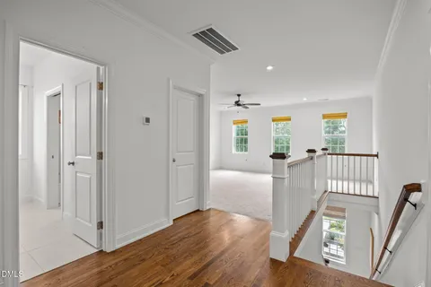 a view of a hallway with wooden floor and windows