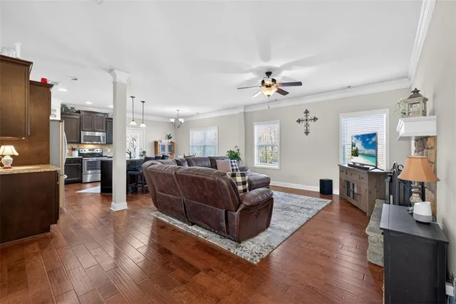a living room with furniture kitchen view and a flat screen tv