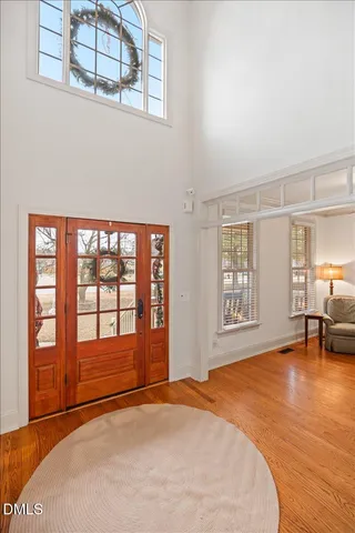 a view of an empty room with window and a kitchen