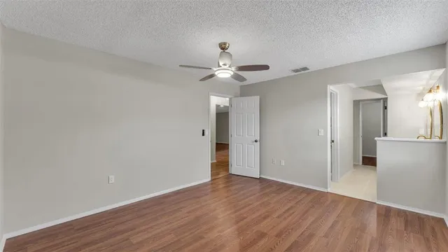a view of a room with wooden floor and a ceiling fan