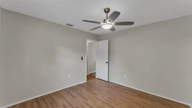 a view of an empty room with wooden floor