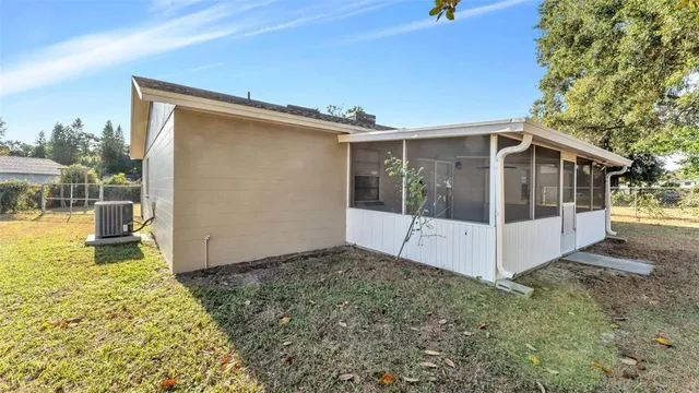 a view of a white house with a big yard and large tree