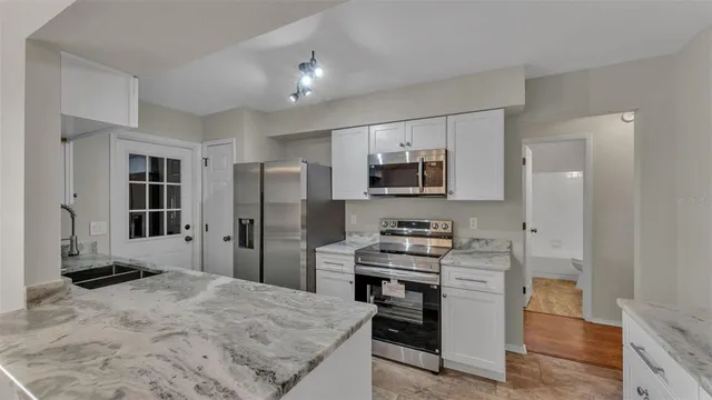 a kitchen with stainless steel appliances a refrigerator and a stove top oven