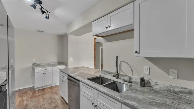 a kitchen with granite countertop a sink stove and cabinets