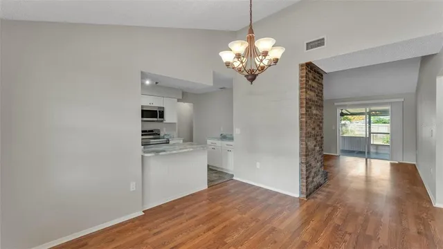 a view of a kitchen with a refrigerator a ceiling fan and wooden floor
