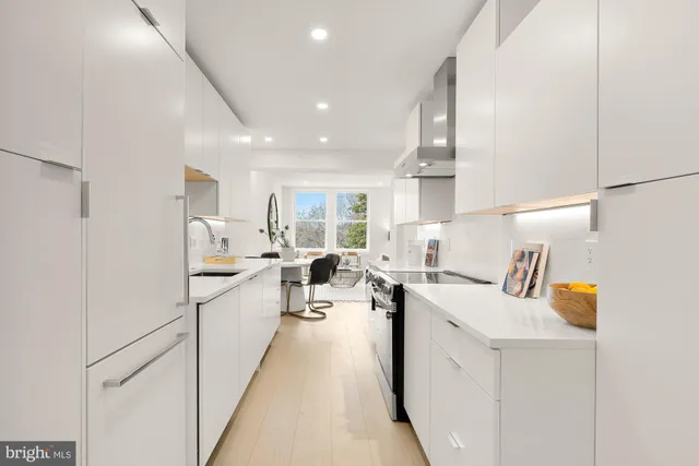 a kitchen with white cabinets and sink