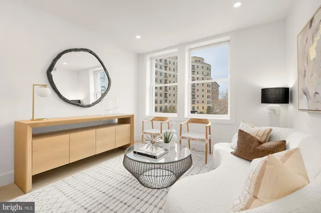 a living room with furniture a window and a flat screen tv