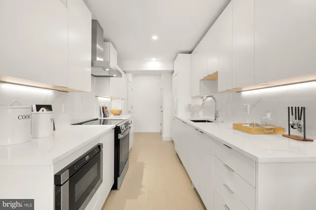 a large kitchen with stainless steel appliances lots of counter space and wooden floor