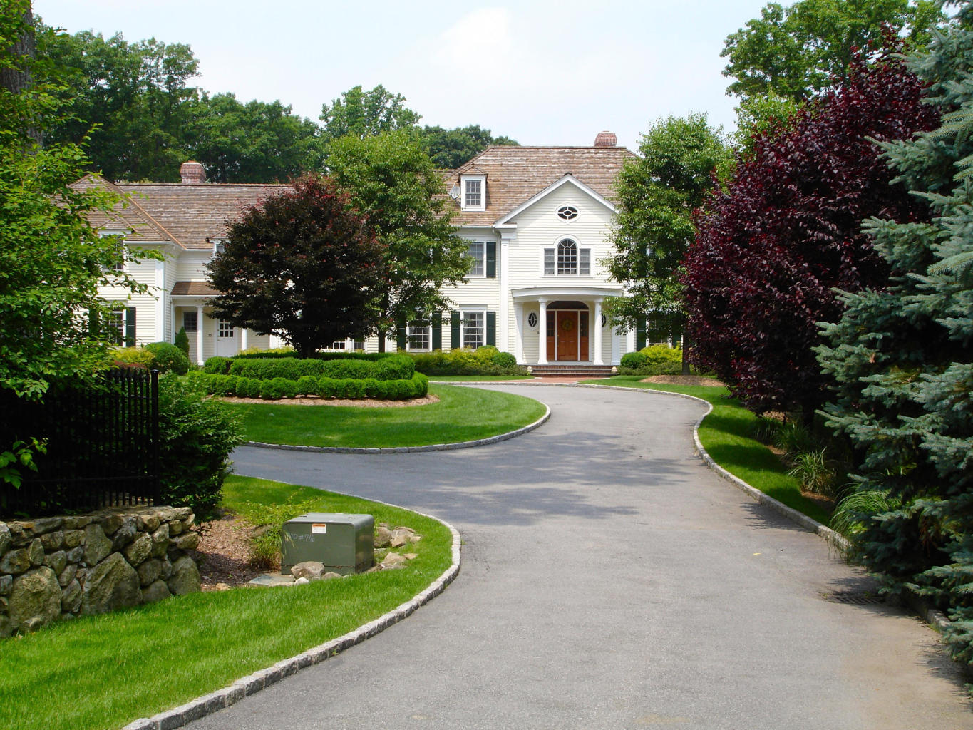 262 Lukes Wood Road New Canaan, CT 06840 - Photo 1 of 34 a front view of a house with a yard and trees