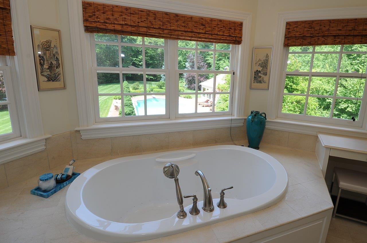 262 Lukes Wood Road New Canaan, CT 06840 - Photo 17 of 34 a bath tub sitting in a bathroom next to a window