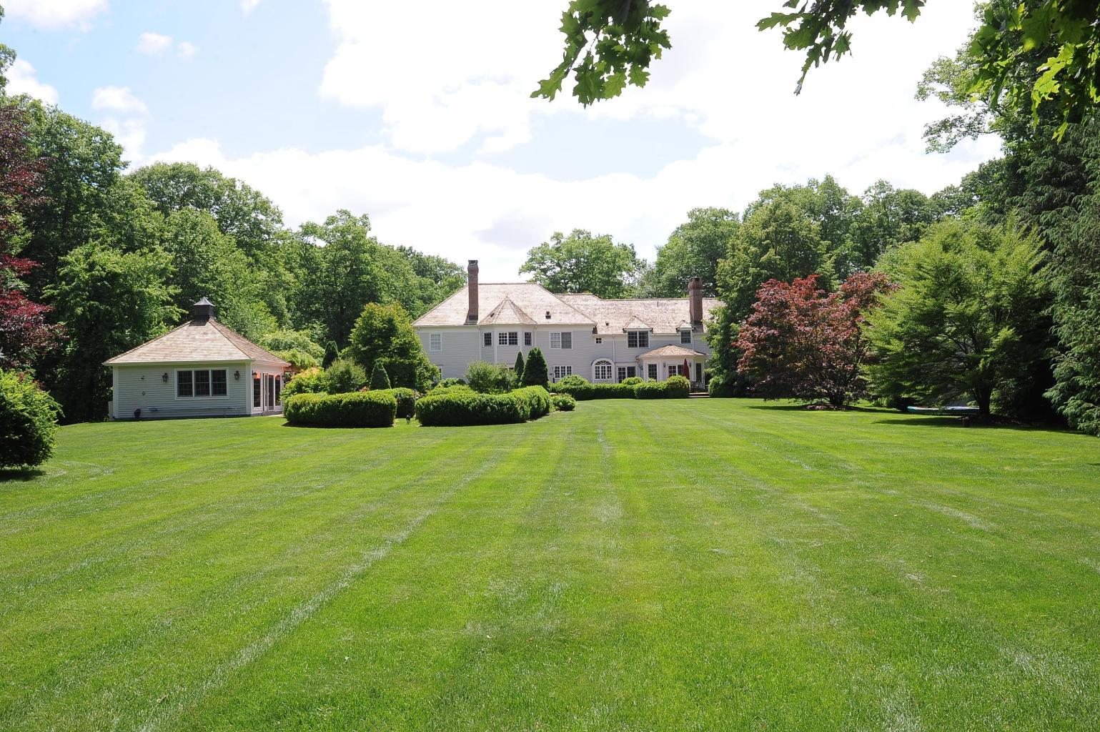 262 Lukes Wood Road New Canaan, CT 06840 - Photo 2 of 34 a view of a house with a big yard potted plants and large tree