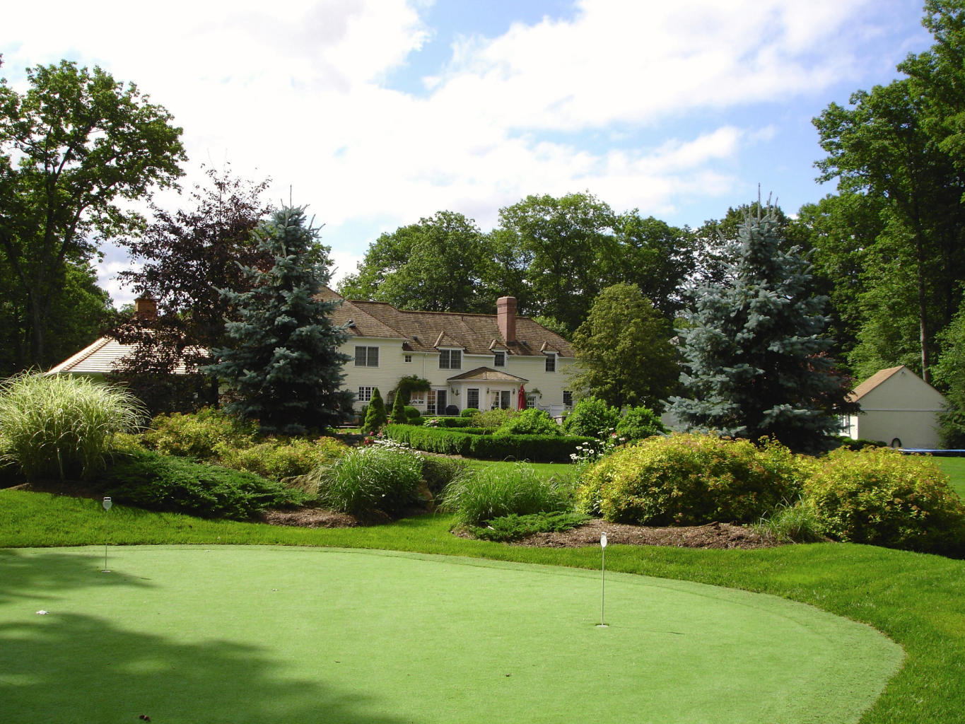 262 Lukes Wood Road New Canaan, CT 06840 - Photo 27 of 34 a view of a garden with a building in the background