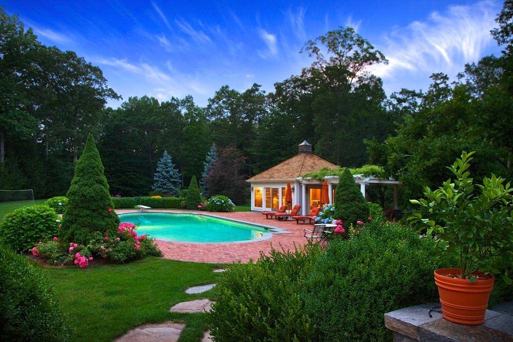 262 Lukes Wood Road New Canaan, CT 06840 - Photo 31 of 34 a front view of a house with a big yard and potted plants