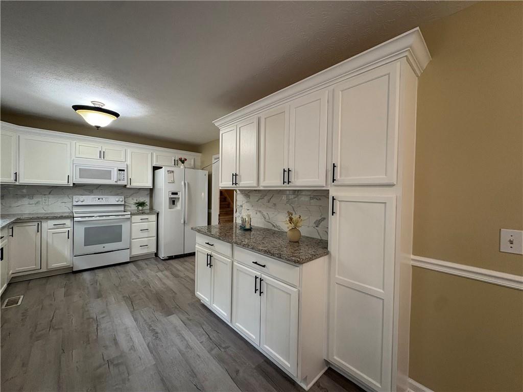 13 Greystone Lane Northwest Cartersville, GA 30121 - Photo 20 of 61 a kitchen with white cabinets and white appliances