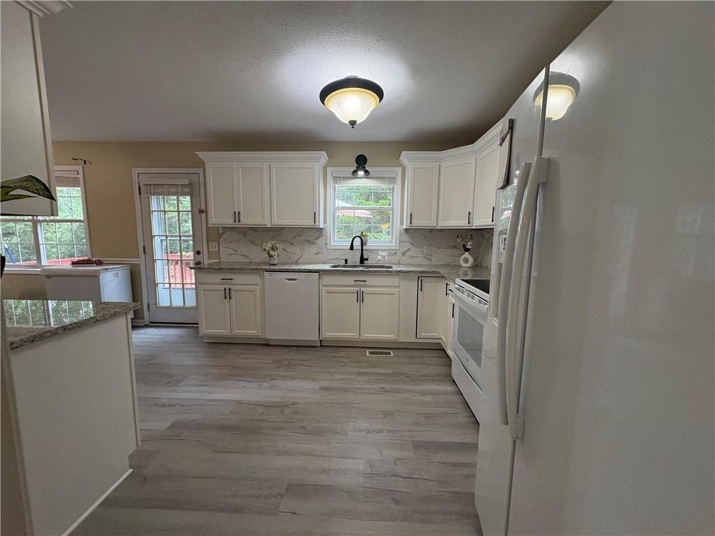 13 Greystone Lane Northwest Cartersville, GA 30121 - Photo 23 of 61 a kitchen with stainless steel appliances granite countertop a stove a sink and a refrigerator