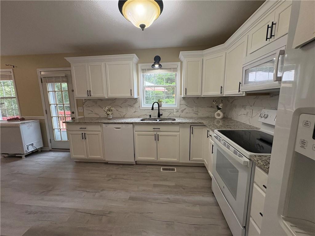 13 Greystone Lane Northwest Cartersville, GA 30121 - Photo 25 of 61 a kitchen with a sink white cabinets and white appliances