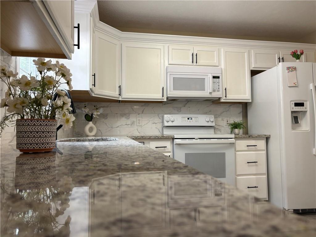 13 Greystone Lane Northwest Cartersville, GA 30121 - Photo 27 of 61 a kitchen with granite countertop a stove a sink and a refrigerator