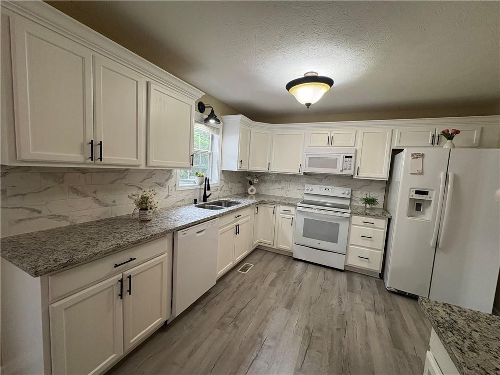 13 Greystone Lane Northwest Cartersville, GA 30121 - Photo 28 of 61 a kitchen with white cabinets and white appliances