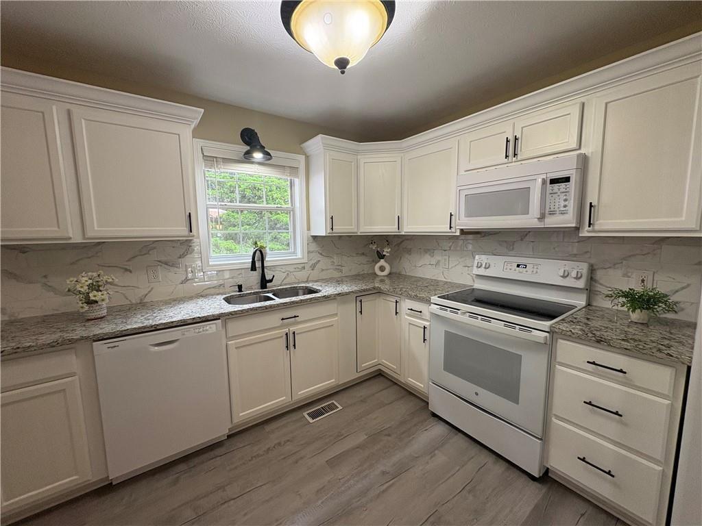 13 Greystone Lane Northwest Cartersville, GA 30121 - Photo 35 of 61 a kitchen with cabinets appliances a sink and a window