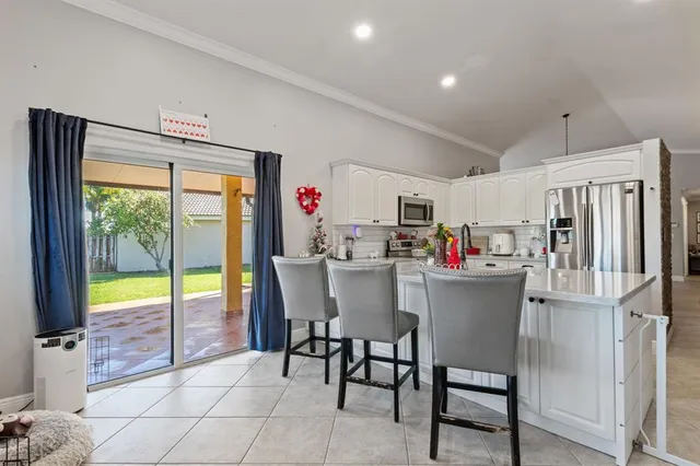 a dining room with furniture and a floor to ceiling window