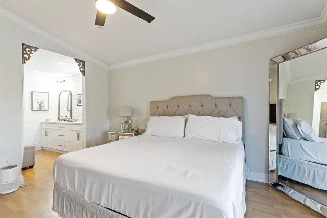 a bedroom with a bed a mirror on dresser and a chandelier