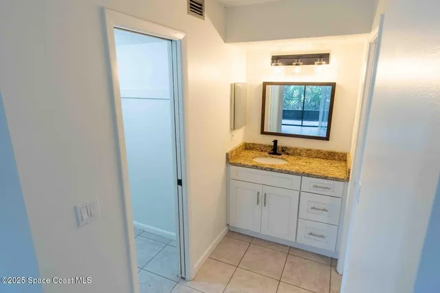 a bathroom with a granite countertop sink and a mirror