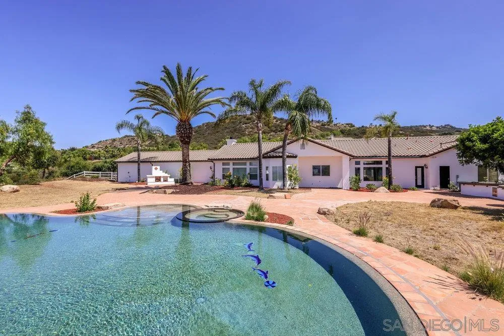 a view of a house with swimming pool and sitting area