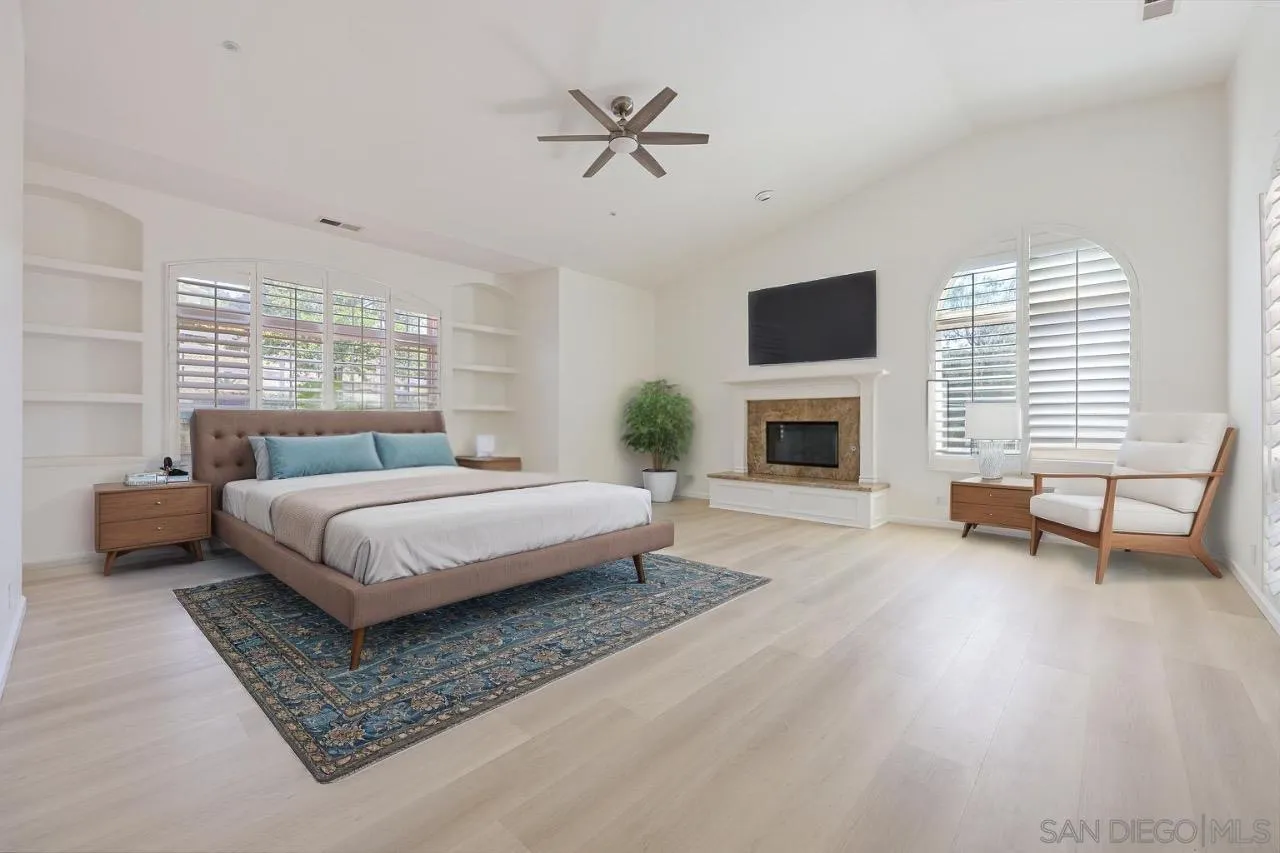 26335 Engelmann Road Valley Center, CA 92082 - Photo 16 of 42 a spacious bedroom with a bed a fireplace and a couch