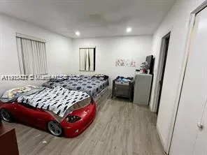 a bedroom with bed and wooden floor
