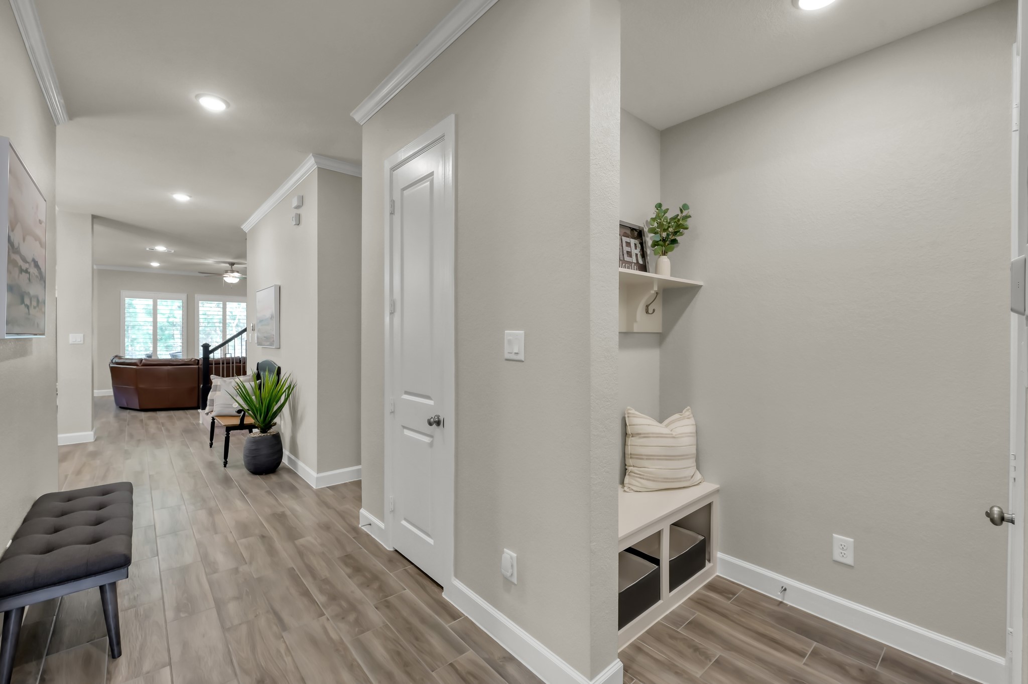 334 Torrey Bloom Loop Conroe, TX 77304 - Photo 12 of 47 Functional mudroom/drop zone with built-in bench and storage, seamlessly connecting to the open-concept living area with continued wood-look flooring.