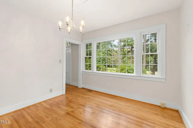 a view of an empty room with a window and a fireplace