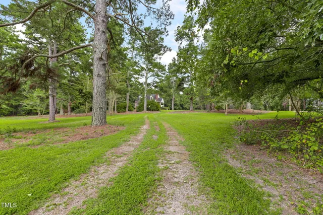 a front view of a house with a yard and trees