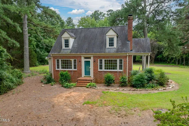 a front view of a house with yard and green space