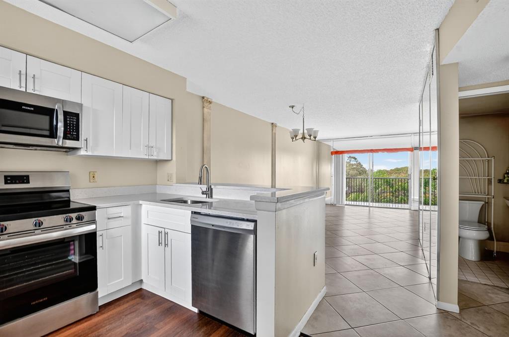 2236 North Cypress Bend Drive, Unit 508 Pompano Beach, FL 33069 - Photo 3 of 69 a kitchen with stainless steel appliances a stove a sink and a microwave