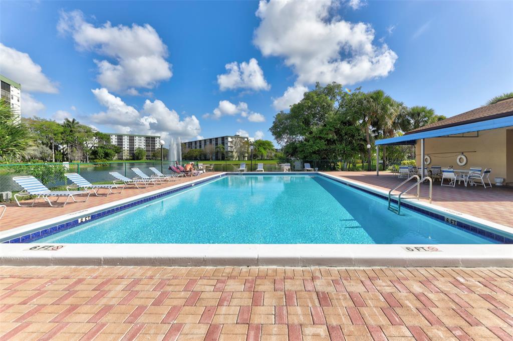 2236 North Cypress Bend Drive, Unit 508 Pompano Beach, FL 33069 - Photo 49 of 69 a view of a swimming pool with a yard
