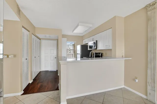 a view of a kitchen with a sink and refrigerator in it