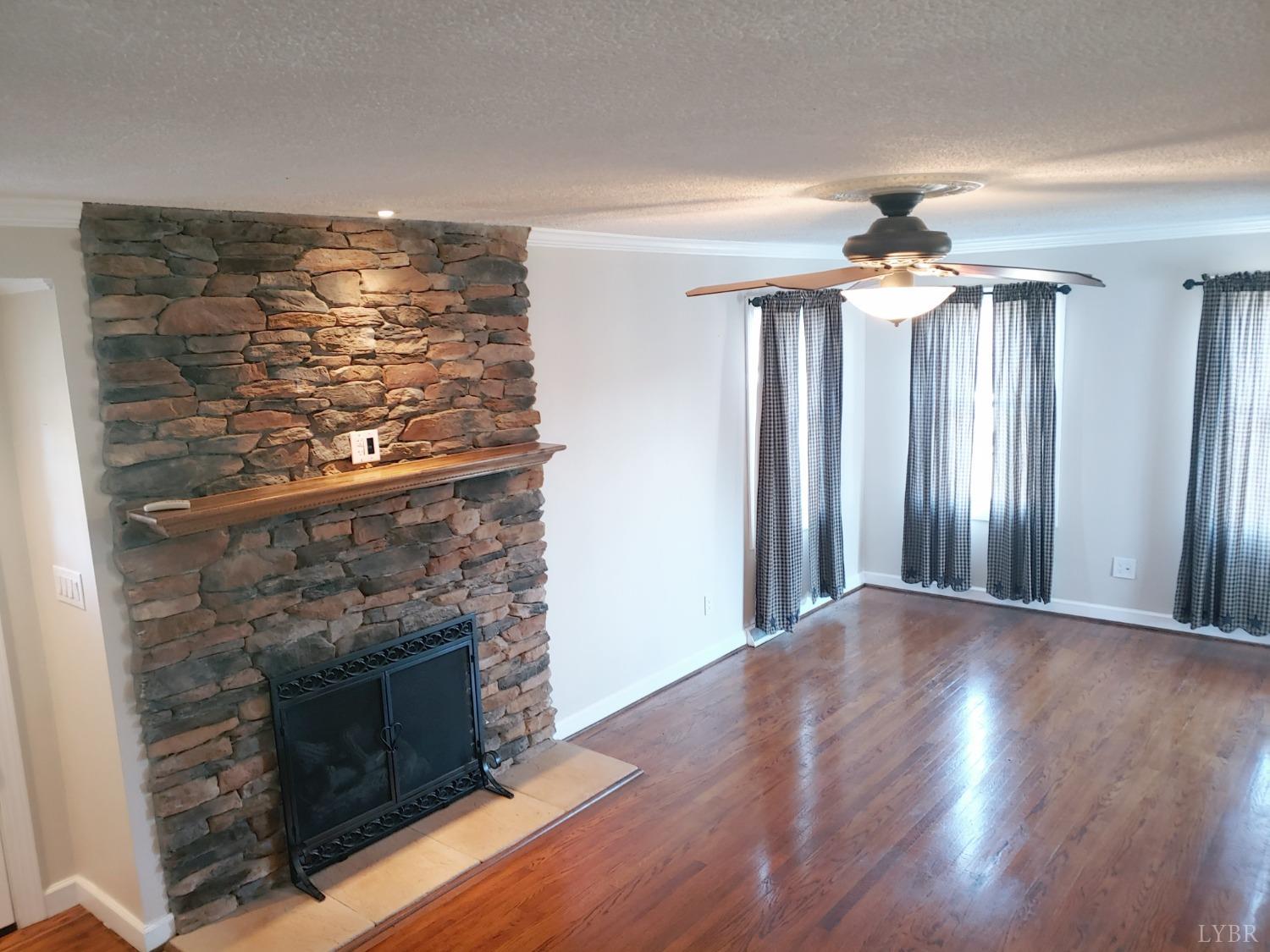 3941 Shula Drive Hurt, VA 24563 - Photo 23 of 67 a view of a livingroom with a fireplace wooden floor and fan