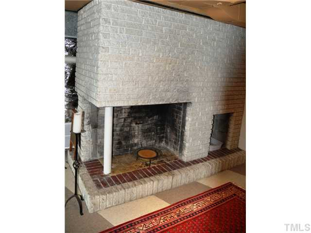722 Graham Street Raleigh, NC 27605 - Photo 18 of 24 The brick fireplace downstairs is another mid-century modern design feature that sets this home apart.