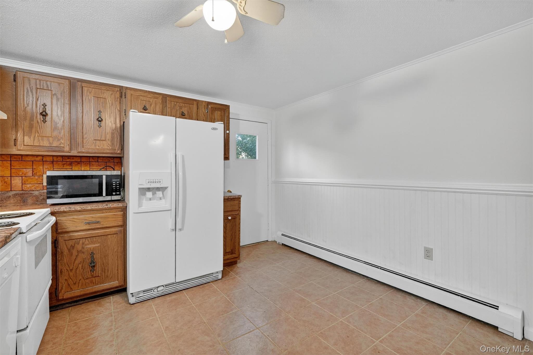 114 Laurel Hill Road Croton-on-Hudson, NY 10520 - Photo 17 of 34 a kitchen with a refrigerator a stove top oven and cabinets