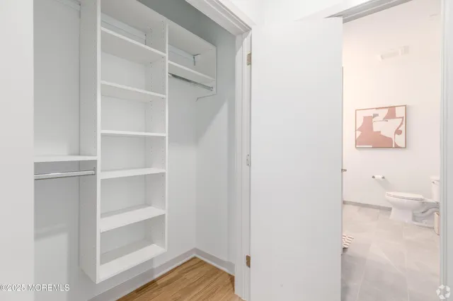 a view of a room with wooden floor and a bathroom