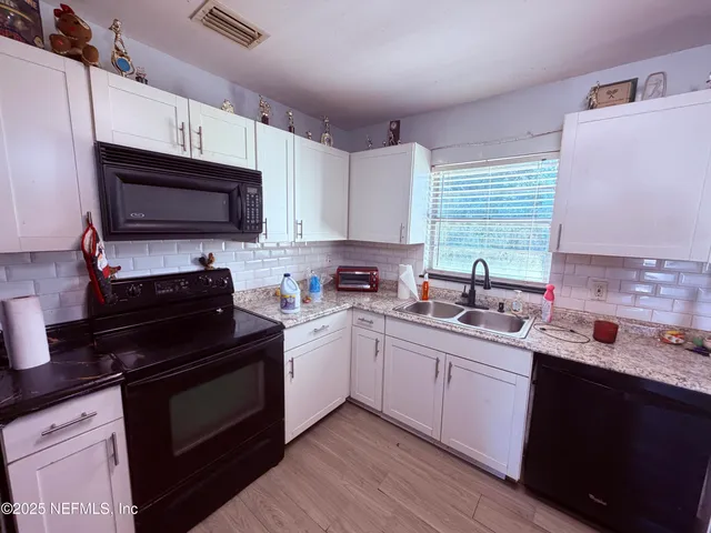 a kitchen with a sink stove and microwave