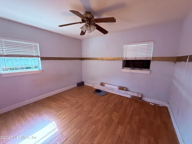 a room with a wooden floor and a ceiling fan