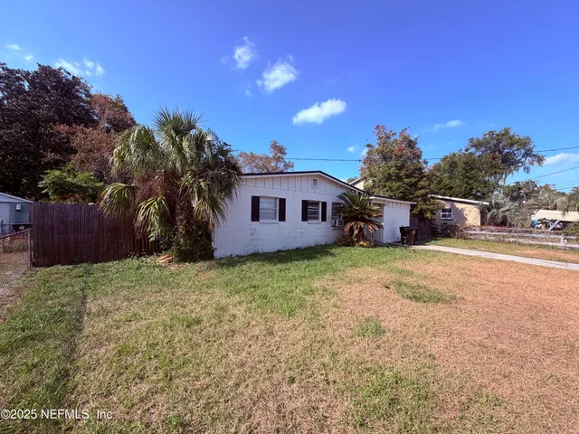 a backyard of a house with table and chairs