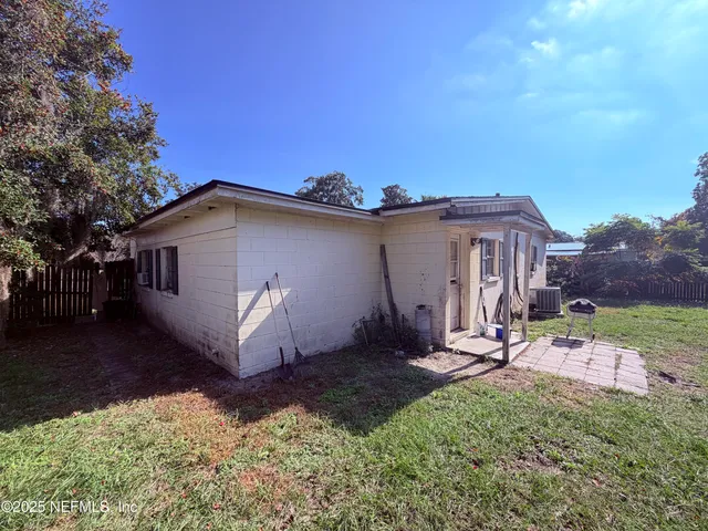 a view of a house with backyard and sitting area