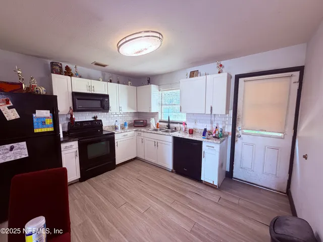 a kitchen with granite countertop stainless steel appliances refrigerator sink and microwave