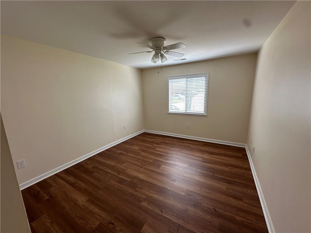 605 Candler Street, Unit C9 Gainesville, GA 30501 - Photo 16 of 18 an empty room with wooden floor ceiling fan and windows