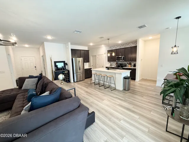 a living room with furniture and a wooden floor