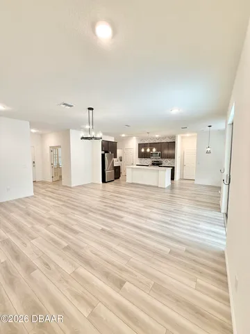 a large kitchen with kitchen island a sink stainless steel appliances and a counter space